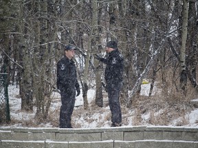 Calgary police search a wooded area west of Westhills Towne Centre near Richmond Road S.W. on Wednesday, Jan. 23, 2019.