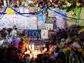 Flowers, notes and candles are piled high at a vigil on Yonge Street in Toronto, April 24, 2018 following a deadly van attack that killed 10 people..