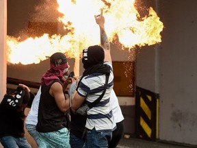 Opposition demonstrators clash with security forces in a protest against the government of President Nicolas Maduro on the anniversary of the 1958 uprising that overthrew the military dictatorship, in Caracas, Venezuela on Wednesday, Jan. 23, 2019.