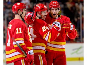 Calgary Flames blueliner Travis Hamonic celebrates with teammates Mikael Backlund and Noah Hanifin after scoring against the New York Islanders in NHL hockey at the Scotiabank Saddledome in Calgary on Wednesday. Photo by Al Charest/Postmedia.