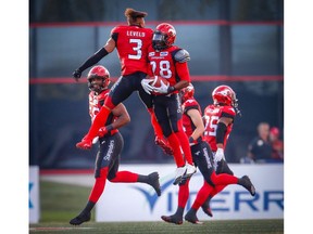 Calgary Stampeders Brandon Smith celebrates with teammate Patrick Levels after his interception against the Montreal Alouettes during CFL football in Calgary on Saturday, July 21, 2018. Al Charest/Postmedia