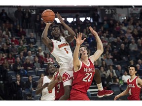 Calgary Dinos' Mambi Diawara, left, shoots over McGill Redmen's Francois Bourque during the first half of semifinal action in the USports men's basketball national championship in Halifax on Saturday, March 10, 2018.