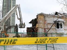 Calgary fire department investigators get an aerial view from a ladder truck as the Enoch Sales historic home in Victoria Park is demolished following a two alarm blaze on Saturday morning February 2, 2019.  Gavin Young/Postmedia