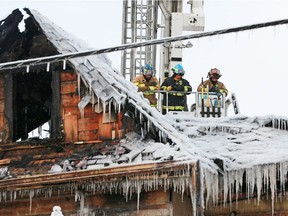 Calgary fire department investigators get an aerial view from a ladder truck as the Enoch Sales historic home in Victoria Park is demolished following a two alarm blaze on Saturday morning February 2, 2019.  Gavin Young/Postmedia