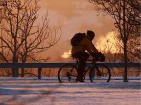 The sun sets as a cyclist rides along Crescent Road at sunset on another cold day in Calgary, Tuesday February 5, 2019.  Gavin Young/Postmedia