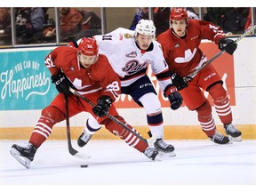 The Calgary Hitmen's James Malm looks to control the puck as the Regina Pats' Carter Massier moves in during WHL action in The Corral Series on Wednesday February 6, 2019. The Hitmen wore Calgary Cowboys jerseys for the game. Gavin Young/Postmedia