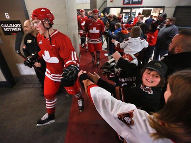 The Calgary Hitmen's Cael Zimmerman fist bumps with fans as he and teammates hit the ice for WHL action against the Regina Pats in The Corral Series on Wednesday February 6, 2019. The Hitmen wore Calgary Cowboys jerseys for the game.