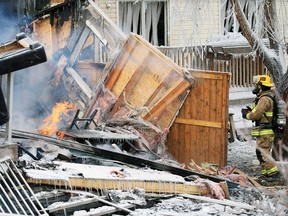 Calgary firefighters deal with the aftermath of a large fire which destroyed one home and damaged others in the 300 block of Douglas Glen Close S.E. early Sunday February 17, 2019. 
Gavin Young/Postmedia