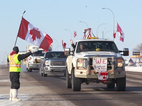 Martin Zobrist greets truckers and supporters as he stands on Highway 1 in Strathmore, AB, 45 km east of Calgary on Thursday, February 14, 2019 as the United We Roll convoy for Canada is eastbound to Ottawa. Zobrist said he left work in Calgary for the day. Jim Wells/Postmedia