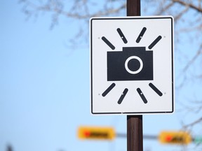 A warning sign for a speed-on-green/ red light camera is posted at 64 Ave and 4 St NE in Calgary Thursday, February 21, 2019. Jim Wells/Postmedia