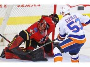 Calgary Flames goaltender Mike Smith makes a save on a shot by Casey Cizikas of the New York Islanders during NHL hockey at the Scotiabank Saddledome in Calgary on Sunday, March 11, 2018. Al Charest/Postmedia