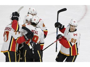 Calgary Flames' Noah Hanifin (55) celebrates with teammates following his goal against the Carolina Hurricanes during the third period of an NHL hockey game in Raleigh, N.C., Sunday, Feb. 3, 2019.