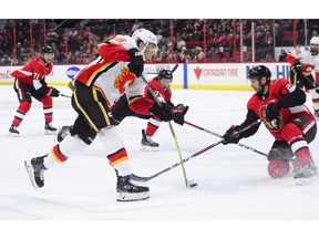 Calgary Flames left wing Matthew Tkachuk (19) takes a shot on net as Ottawa Senators defenceman Dylan DeMelo (2) attempts to block it during the first period NHL hockey action in Ottawa on Sunday, Feb. 24, 2019.