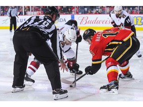 CALGARY, AB - FEBRUARY 18: Mikael Backlund #11 of the Calgary Flames faces off against Vinnie Hinostroza #13 of the Arizona Coyotes during an NHL game at Scotiabank Saddledome on February 18, 2019 in Calgary, Alberta, Canada.