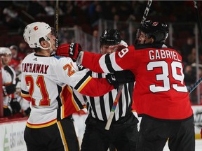 NEWARK, NEW JERSEY - FEBRUARY 27: Kurtis Gabriel #39 of the New Jersey Devils gets a glove up on Garnet Hathaway #21 of the Calgary Flames during the third period at the Prudential Center on February 27, 2019 in Newark, New Jersey. The Flames defeated the Devils 2-1.