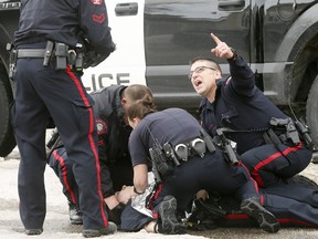 Calgary Police tend to one of their own who was shot at a scene in Abbeydale on Tuesday March 27, 2018. Darren Makowichuk/Postmedia