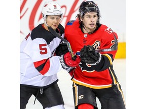 New Jersey Devils Connor Carrick battles Sean Monahan of the Calgary Flames during NHL hockey at the Scotiabank Saddledome in Calgary on Tuesday, March 12, 2019. Al Charest/Postmedia