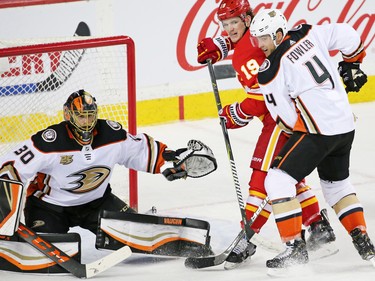 The Calgary Flames' Matthew Tkachuk and the Anaheim Ducks' Cam Fowler jostle for position in front of Anaheim Ducks goaltender goalie Ryan Miller during third period NHL action in Calgary on Friday, March 29, 2019.