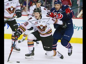 Calgary Hitmen Carson Focht and the Lethbridge Hurricanes' Jake Leschyshyn race for the puck during their play-off game in Calgary on Sunday, March 31, 2019. The Hurricanes won the game 7-6 in overtime forcing a seventh game back in Lethbridge.