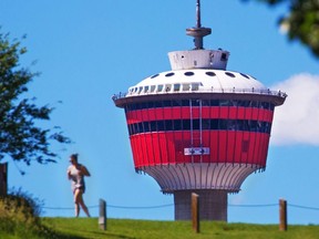 A jogger runs along a road in Ramsay as the Calgary Tower rises in the background on Wednesday June 27, 2018. The tower's 50th anniversary is being celebrated this weekend with a block party on 9th Avenue on Saturday. Gavin Young/Postmedia