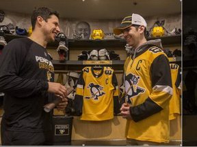 Penguins star Sidney Crosby (left) and Humboldt Broncos bus crash survivor Layne Matechuk pose for a photo in the team’s dressing room at PPG Paints Arena in Pittsburgh yesterday. Matechuk, whose hockey hero is Crosby, was invited to take in the Penguins-Capitals game last night. Liam Richards/Postmedia Network