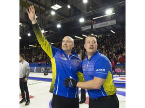 Team Alberta skip Kevin Koe (left) celebrates his win over Team Wild Card with lead Ben Hebert in the final draw at the Brier in Brandon, Man. Sunday, March 10, 2019.