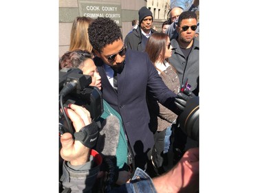 Actor Jussie Smollett poses for a selfie outside the Leighton Criminal Court Building after a hearing Tuesday, March 26, 2019, in Chicago. Smollett attorneys Tina Glandian and Patricia Brown Holmes said in a statement Tuesday that Smollett's record "has been wiped clean." Smollett was indicted on 16 felony counts related to making a false report that he was attacked by two men who shouted racial and homophobic slurs.