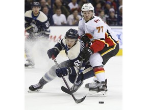 Calgary Flames' Mark Jankowski, right, and Columbus Blue Jackets' Markus Nutivaara, of Finland, chase a loose puck during the first period of an NHL hockey game Tuesday, Dec. 4, 2018, in Columbus, Ohio.