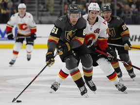 Vegas Golden Knights right wing Mark Stone (61) skates around Calgary Flames center Sean Monahan (23) during the second period of an NHL hockey game Wednesday, March 6, 2019, in Las Vegas.