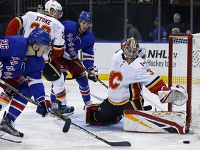 With Rangers forwards ready to pounce, Calgary Flames goaltender David Rittich watches a shot go wide on Oct. 21, 2018, in New York.