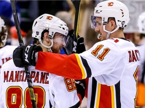 Calgary Flames' Andrew Mangiapane (88) and teammate Mikael Backlund (11) celebrate their teams win after NHL hockey action against the Vancouver Canucks, in Vancouver on Saturday, March 23, 2019.