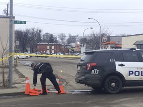 An Edmonton police officer sets up pylons outside of a Whyte Avenue bar where police said one person has died on Sunday, March 24, 2019. (Photo by Jonny Wakefield/Postmedia)