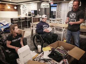 Humboldt Broncos' Ryan Straschnitzki and parents Michelle and Tom look through gifts in the lobby of the hotel  they have been living at for six months in Airdrie on Dec. 19, 2018.