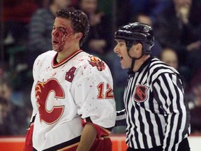 Calgary-01/21/01-A linesman helps a bloody Jarome Iginla to the Calgary Flames bench following a fight late in the opening period of last nights game against the Detroit Red Wings.