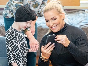 Nattie Neidhart trying to make a young patient smile by showing her funny pics of cats. (Submitted Photo)