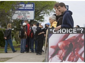 Demonstrators from the Canadian Centre for Bio-Ethical Reform hold an abortion protest on the sidewalk outside Jack James Public High School in Calgary on June 8, 2011.