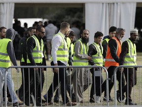 Security personnel walk on the site of funeral services in Christchurch, New Zealand, Wednesday, March 20, 2019.