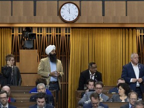 The clock reads one minute to midnight as Liberal MPs Brenda Shanahan, left, Randeep Sarai, Ramesh Sangha and Darrell Samson rise to vote during a marathon voting session as it continues into the night in the House of Commons on Parliament Hill in Ottawa on Wednesday, March 20, 2019.