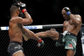 Kamaru Usman, right, kicks Tyron Woodley during a welterweight mixed martial arts title fight at UFC 235, Saturday, March 2, 2019, in Las Vegas.