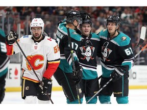 ANAHEIM, CALIFORNIA - APRIL 03:  Hampus Lindholm #47 and Rickard Rakell #67 congratulate Sam Steel #34 of the Anaheim Ducks after his goal as Oliver Kylington #58 of the Calgary Flames looks on  during the first period of a game at Honda Center on April 03, 2019 in Anaheim, California.