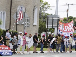 Supporters wait for the Motorcade carrying President Donald Trump returning to Mar-a-Lago on Sunday, March 24, 2019, in West Palm Beach, Fla. (AP Photo/Terry Renna)