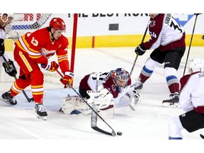 Calgary Flames Sean Monahan and goalie Philipp Grubauer of the Colorado Avalanche battle for a loose puck in game two of the Western Conference First Round during the 2019 NHL Stanley Cup Playoffs at the Scotiabank Saddledome in Calgary on Saturday, April 13, 2019. Al Charest/Postmedia