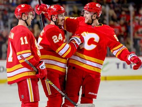 Calgary Flames Travis Hamonic celebrates with teammates Mikael Backlund and Noah Hanifin after scoring against the New York Islanders in NHL hockey at the Scotiabank Saddledome in Calgary on Wednesday, February 20, 2019. Al Charest/Postmedia