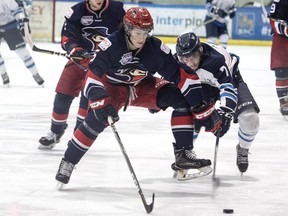 Canmore Eagle Jake Ashton stretches for the puck with Brooks Bandit Brandon Scanlin during their AJHL playoff game at the Canmore Recreation Centre on Sunday, March 11, 2018. photo by Pam Doyle/www.pamdoylephoto.com