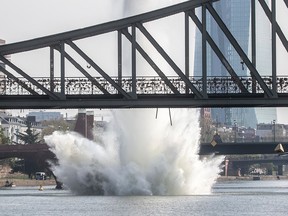A large water fountain rises behind the Iron Bridge when a 250 kilogram U.S.-American bomb from the Second World War in the Main River is detonated with a blast in Frankfurt, Germany, Sunday, April 14, 2019.