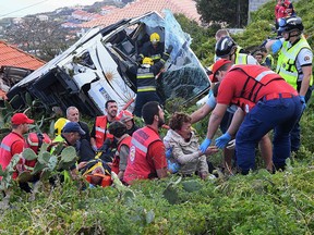 Firemen help victims of a tourist bus that crashed on April 17, 2019 in Canico, on the Portuguese island of Madeira. (RUI SILVA/AFP/Getty Images)