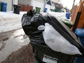 A stuffed black bin in northeast Calgary was photographed on Saturday March 16, 2019. City bureaucrats are proposing council implement a tag-a-bag system for black cart trash, which would see any bags that canít fit in the bins cost $3 apiece. Gavin Young/Postmedia