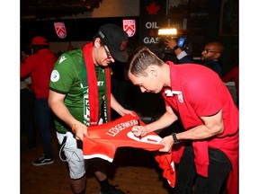 Nik Ledgerwood (R), from Lethbridge, signs a jersey for a fan during the official roster unveil for Cavalry FC of the Canadian Premier League at Barcelona Tavern in Calgary on Wednesday, April 24, 2019. The team opens its regular season in Calgary at Spruce Meadows on May 4. Jim Wells/Postmedia