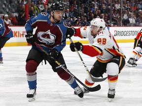 Calgary Flames left wing Andrew Mangiapane, right, checks Colorado Avalanche right wing Sven Andrighetto after Andrighetto had passed the puck during the second period of Game 4 of an NHL hockey playoff series Wednesday, April 17, 2019, in Denver. (AP Photo/David Zalubowski) ORG XMIT: CODZ125