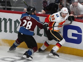 Colorado Avalanche defenseman Ian Cole, left, uses his stick to slow Calgary Flames center Sam Bennett who pursues the puck in the first period of Game 3 of a first-round NHL hockey playoff series Monday, April 15, 2019, in Denver. (AP Photo/David Zalubowski) ORG XMIT: CODZ103